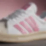 Close-up view of Adidas footwear showcasing white with pink stripes