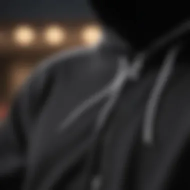 Close-up of the black zip-up hoodie showcasing white strings